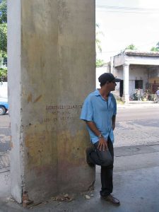 Rolando García Milián, native of Santos Suárez, ironically braces his foot against a wall stamped with the text of a Law-Decree announcing that it is illegal to brace one’s feet against the wall - 2005